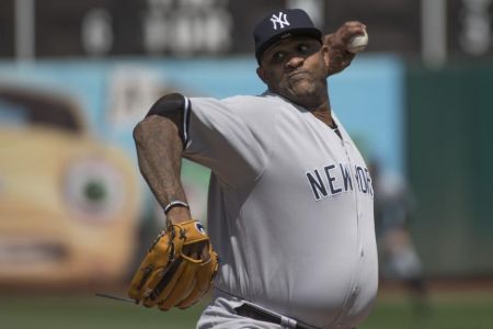 CC Sabathia in the Yankees jersey throwing a ball.